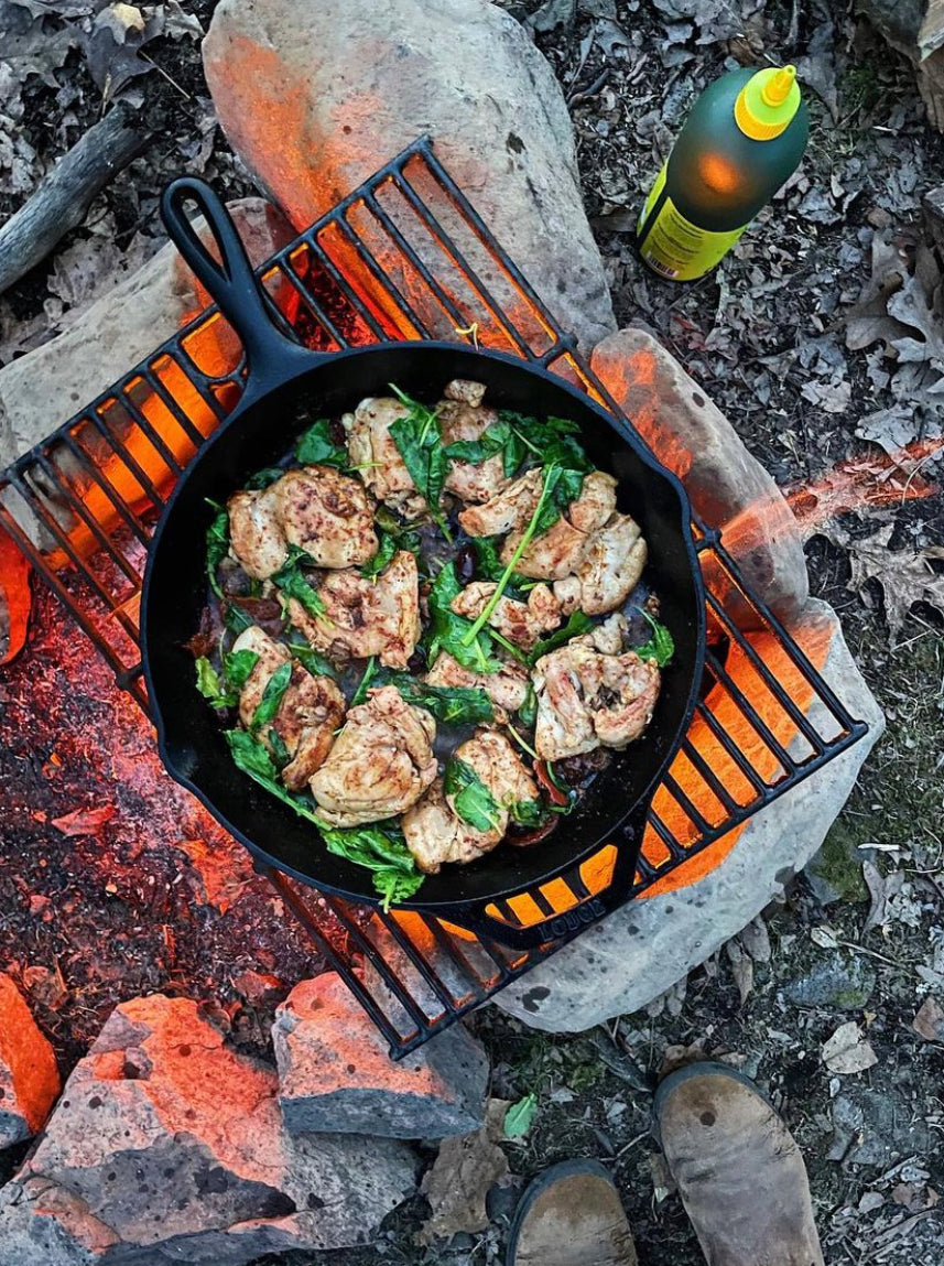 A cast iron skillet over a fire with Graza Sizzle
